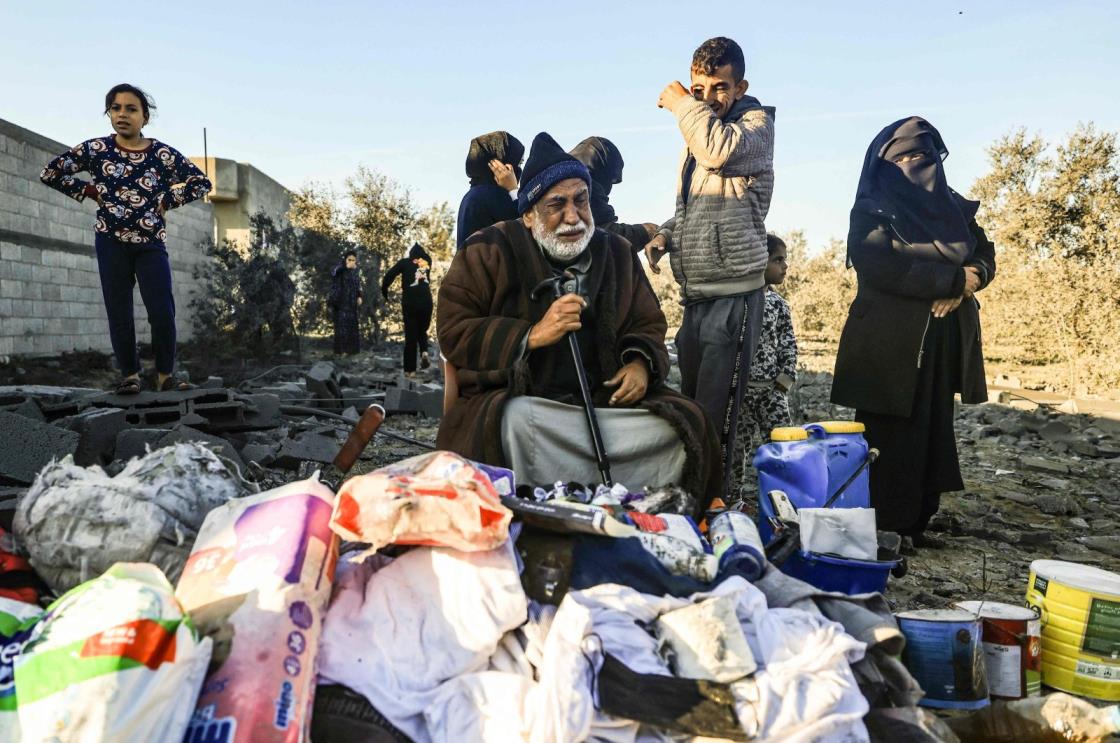 A displaced Palestinian man reacts as he sits among objects salvaged from a house that was used as a shelter by his extended family members, many of whom were reported killed when it was destroyed during an Israeli strike on Rafah in the southern Gaza Strip on Jan. 7, 2024, (AFP Photo)